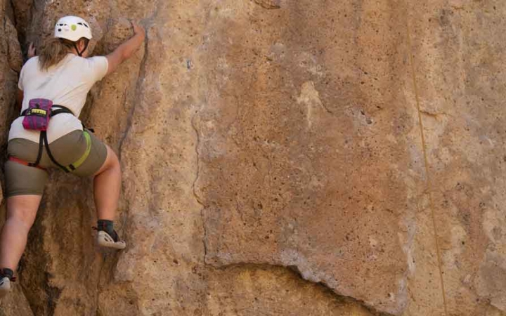 an outward bound student climbs a rock wall on an expedition in the pacific northwest